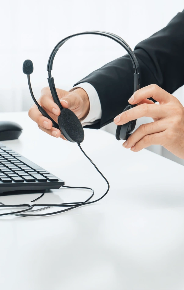 Hands holding a support headset at a desk